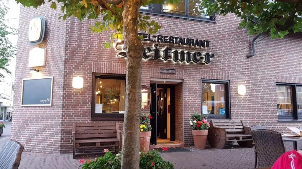a brick building with a sign that reads restaurant furniture at Hotel Deitmer in Rhede