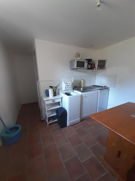 a small kitchen with white appliances and a tile floor at Studio in Isigny-sur-Mer