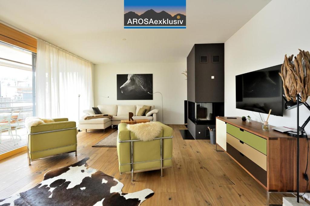 a living room with a couch and a tv at Fontana in Arosa