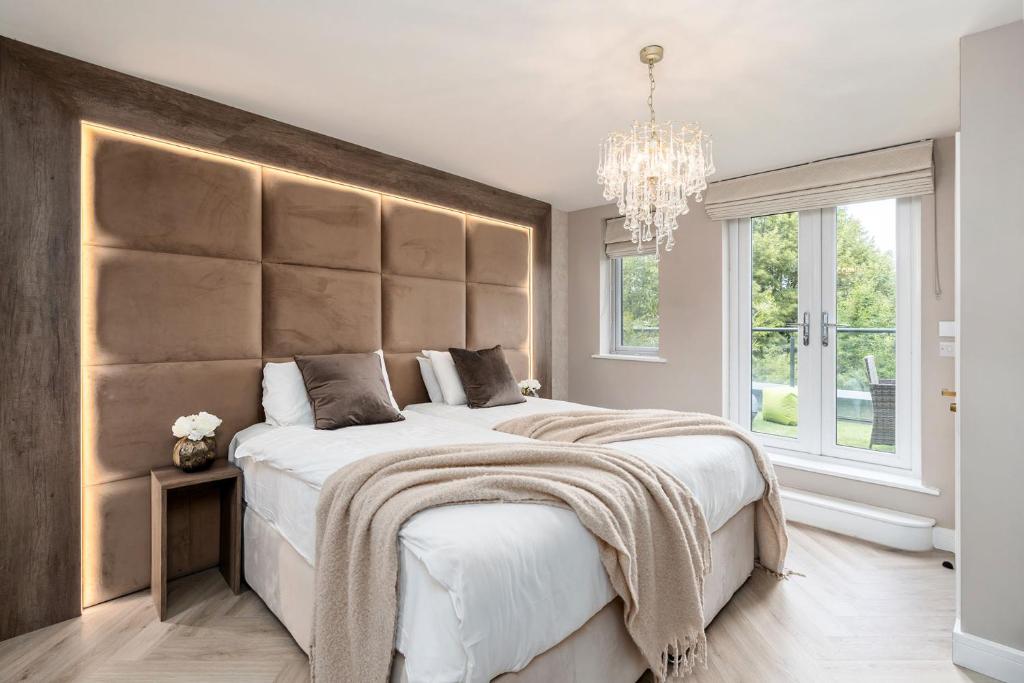 a bedroom with a large bed and a chandelier at Riverside Villas in Manchester