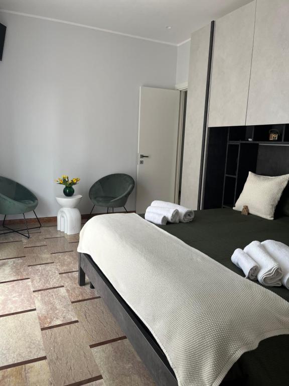 a bedroom with a bed and two chairs at Vittorino house in Polignano a Mare