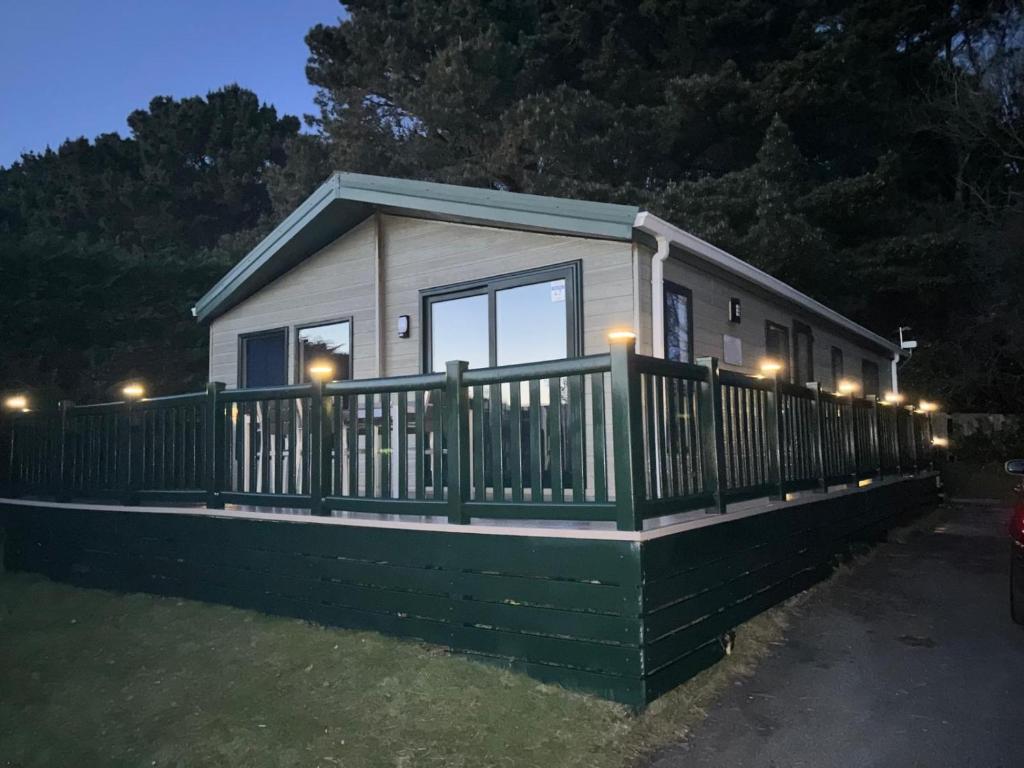 a tiny house with a fence and lights on it at Newquay - Deluxe 3 bed Lodge Willows Way 47, Newquay Parkdean, Holiday Park in Newquay