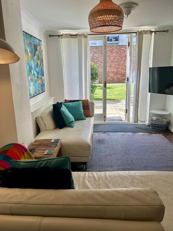 a living room with a couch and a tv at Garden Apartment by the Pier in Portsmouth