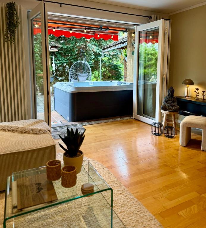 a living room with a tub and a glass table at Garden Spa Suite - Private Sauna & Whirlpool in Betzdorf