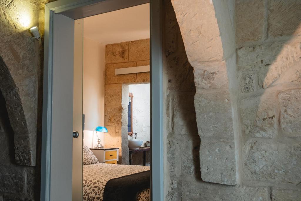 a doorway into a bedroom with a stone wall at Palazzo Mandurino luxury relais in Zollino