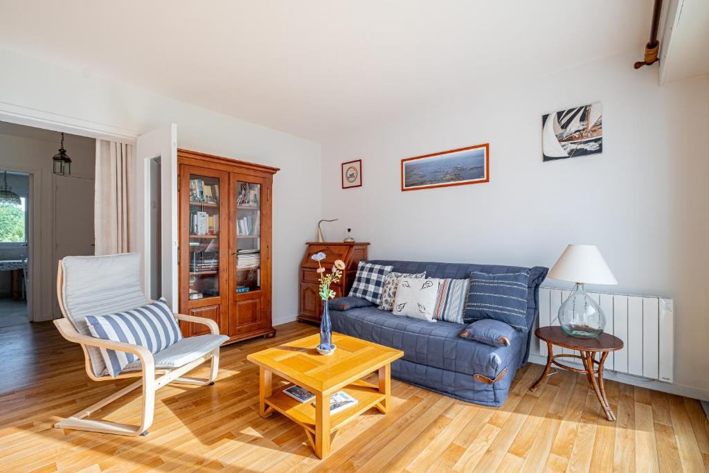 a living room with a blue couch and a table at L'Instant Arradon - Pointe & sentiers côtiers in Arradon