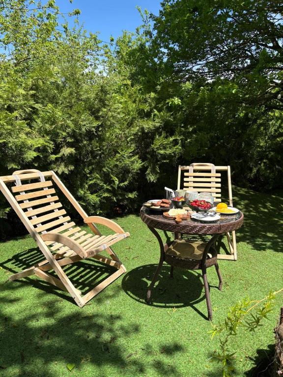 two chairs and a table and a table with food on it at Shin Boutique Hotel with Mini Golf Terrace in Buriaki
