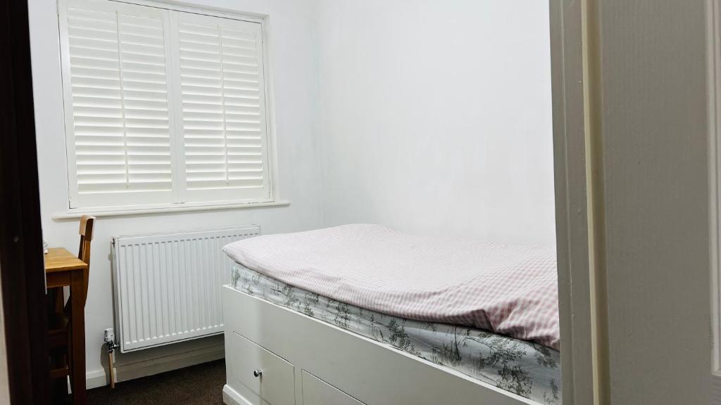 a small bedroom with a bed and a window at Budget Stay In Luton 01 R in Luton