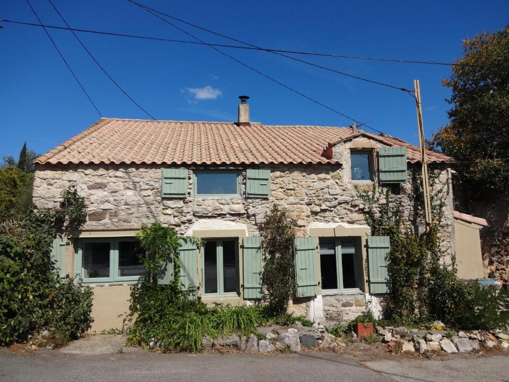 an old stone house with green shutters at Bergerie L'Occitane in La Caunette