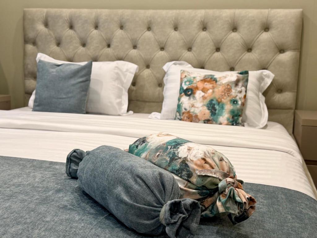 a bed with a headboard and a pillow on it at Aurora Hotel Batumi in Batumi