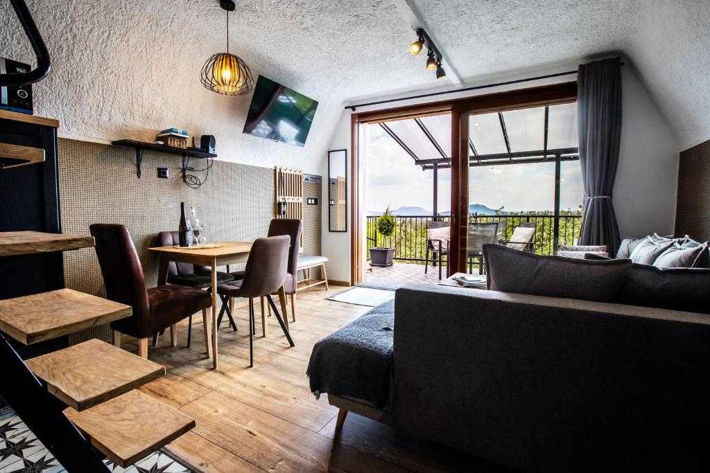 a living room with a couch and a table with chairs at Galaxy6189 Guesthouse in Tapolca