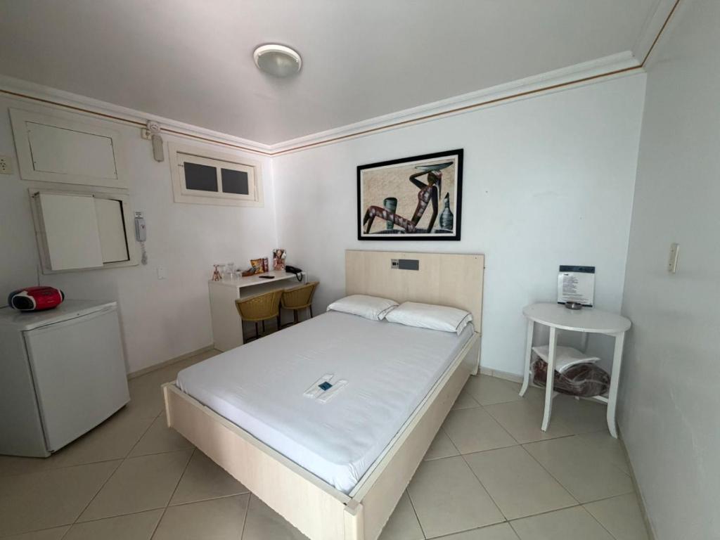 a small bedroom with a bed and a desk at Lemonte Motel in Brusque