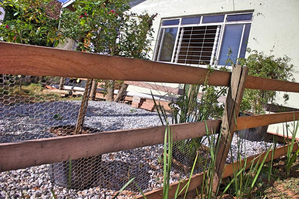 a fence in front of a house with a garden at Estúdio Confortável e Completo em Localização Privilegiada in Curitiba