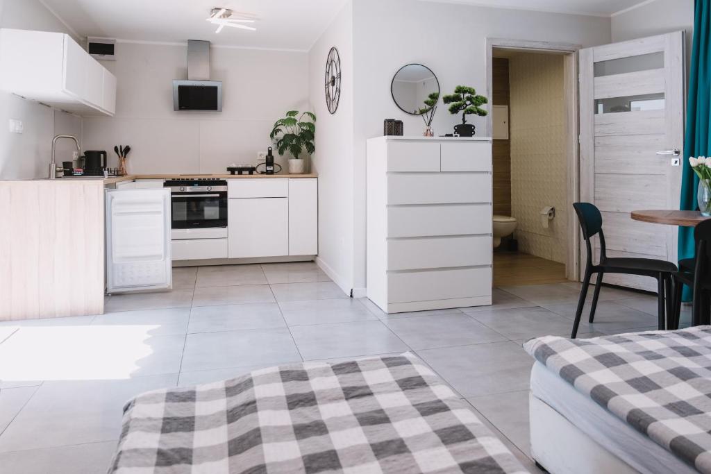 a kitchen with white cabinets and a table and chairs at Noclegi Witnica in Witnica
