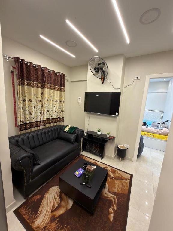 a living room with a black couch and a table at شقة فندقية غرفة واحدة in Mansoura