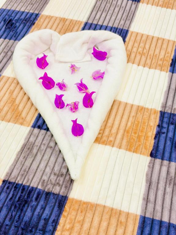 a heart shaped towel with pink butterflies on a bed at TJ Signature Spaces in Point Pedro
