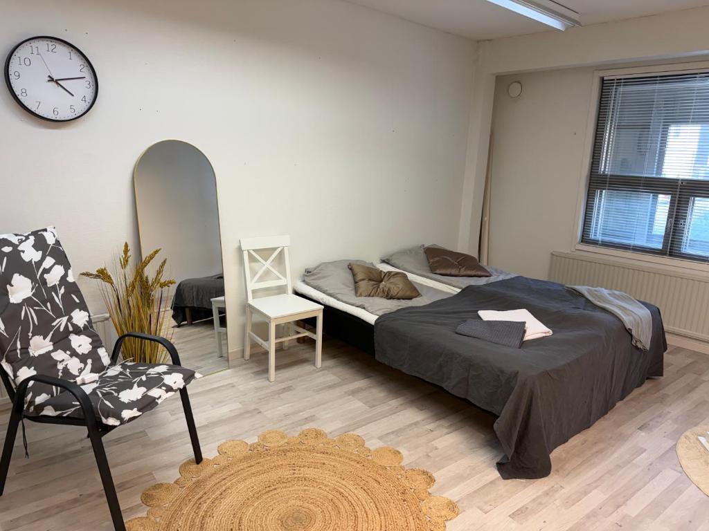 a bedroom with a bed and a clock on the wall at Office to sleep in heard of Lohja in Lohja
