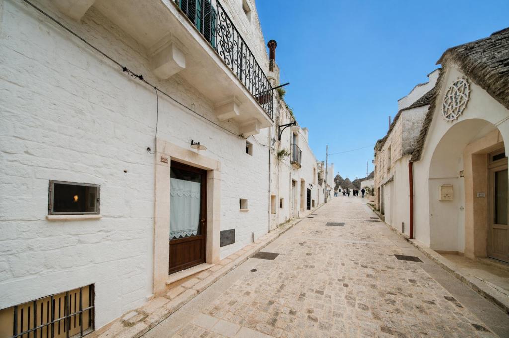 an empty street in an alley with white buildings at Casa del Ramaiolo in Alberobello