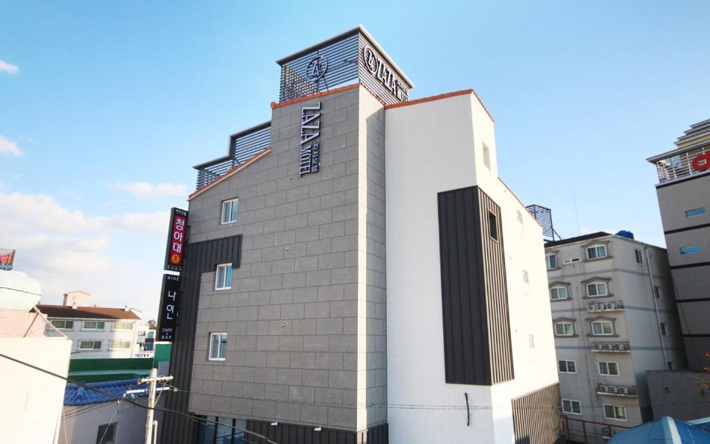 a tall white building in the middle of a city at 자자호텔 in Goseong