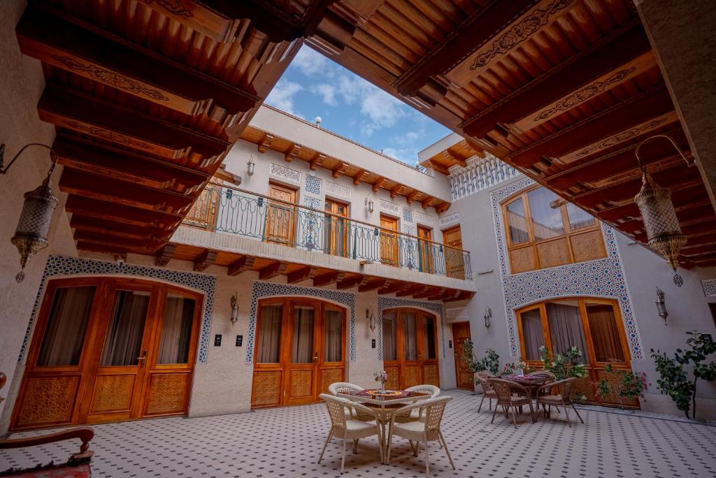 an outdoor patio with tables and chairs in a building at Asal Boutique Hotel in Bukhara