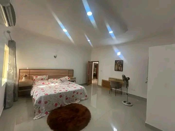 a bedroom with a bed and a desk in it at Appartement meublé service in Cotonou