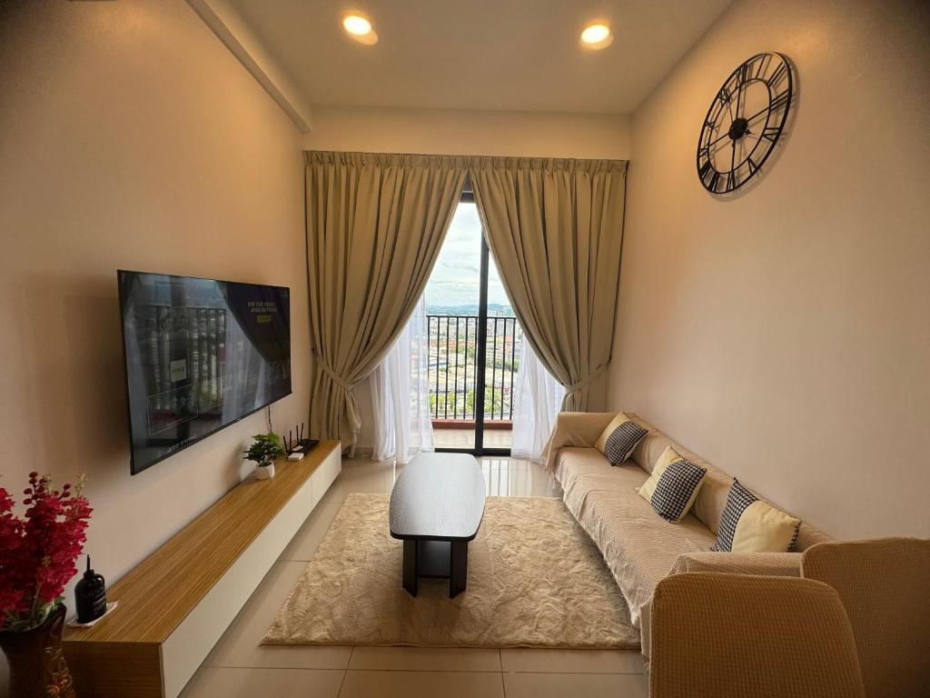 a living room with a couch and a clock on the wall at Piccadilly Greentown Ipoh by Jun - City Views in Ipoh
