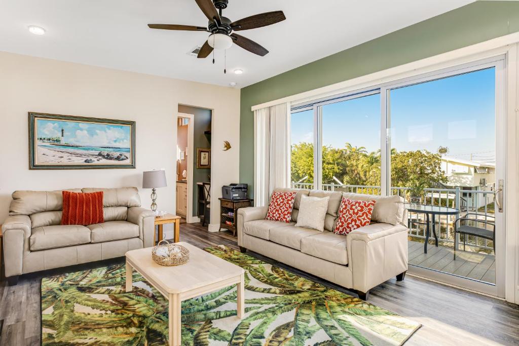 a living room with two couches and a large window at BP07FLR Big Pine Key Dreams in Big Pine Key