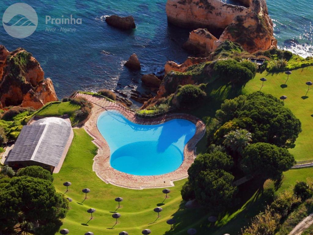 an aerial view of a swimming pool next to the ocean at Aldeamento Turistico da Prainha in Alvor