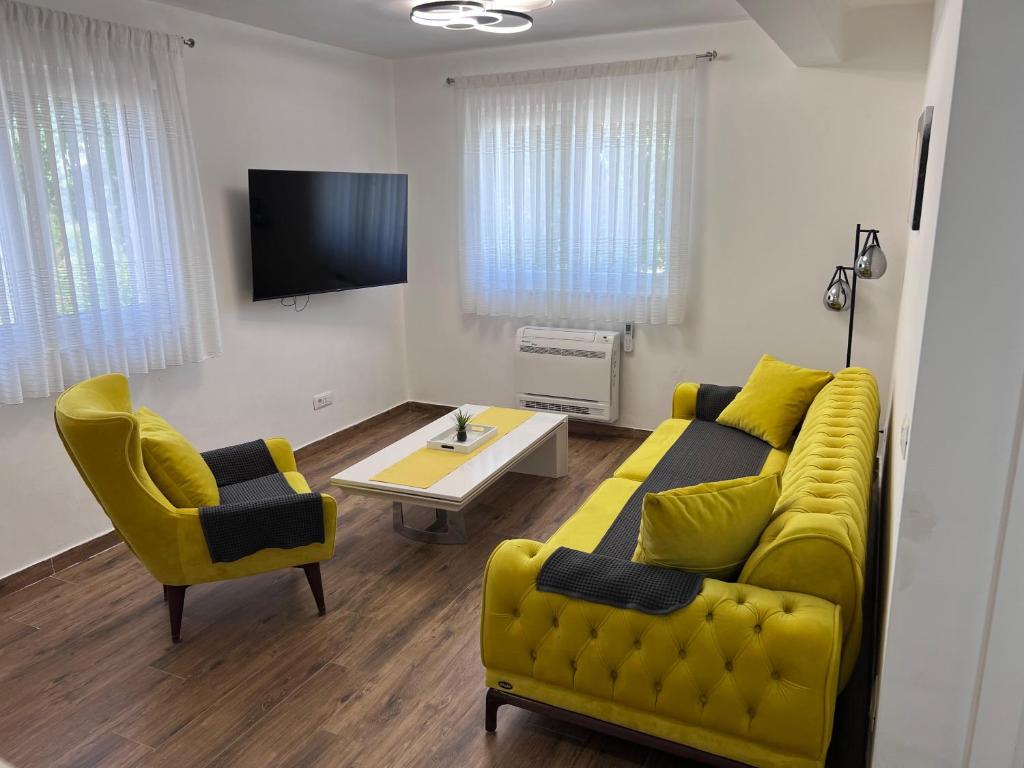 a living room with a yellow couch and a table at Apartman Quattro 2 in Međugorje