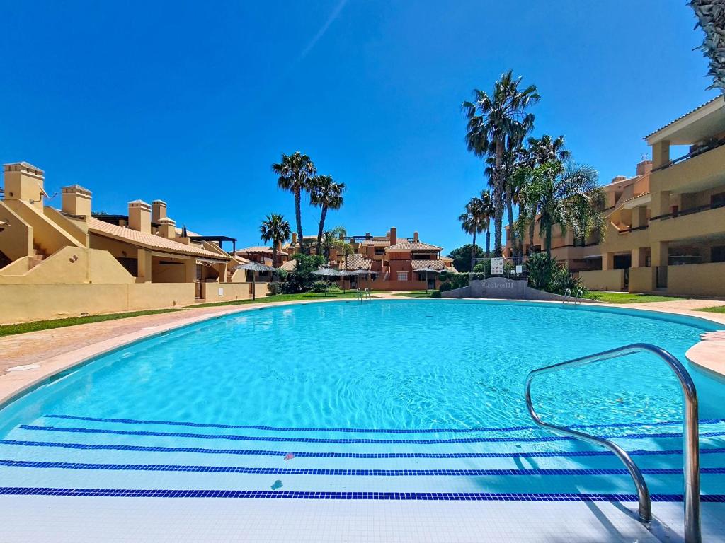 a large swimming pool with palm trees and buildings at Albatros Playa 3 - 3409 in Mar de Cristal