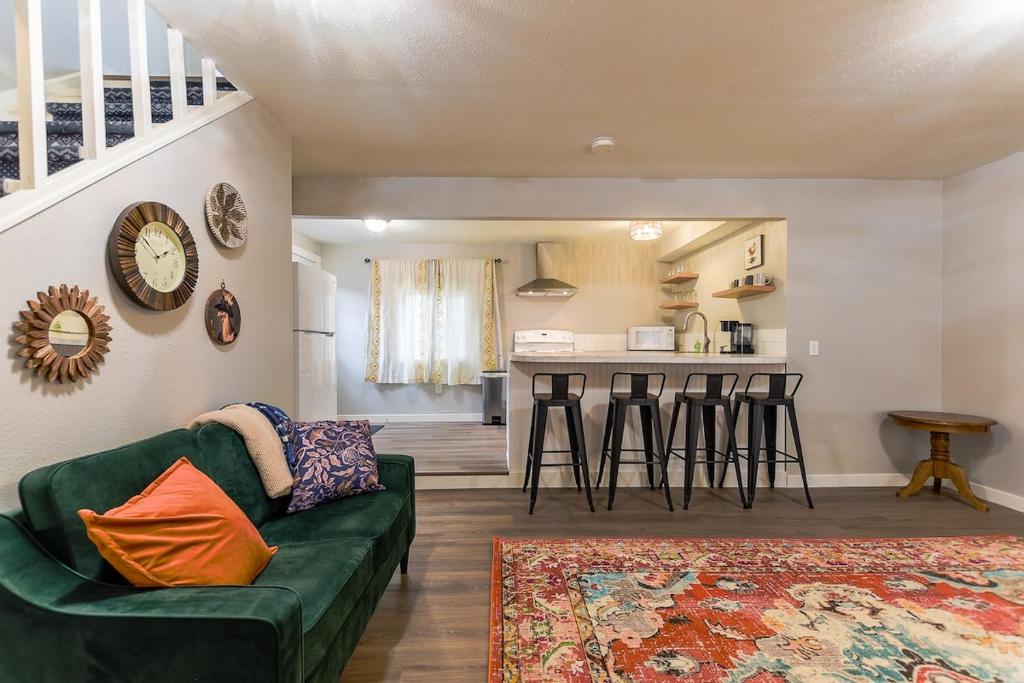 a living room with a green couch and a kitchen at The Palouse Perch in Moscow