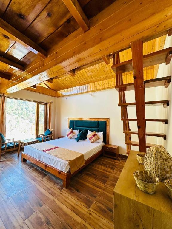 a bedroom with a bed in a room with wooden ceilings at Above & Beyond - Tirthan in Banjār