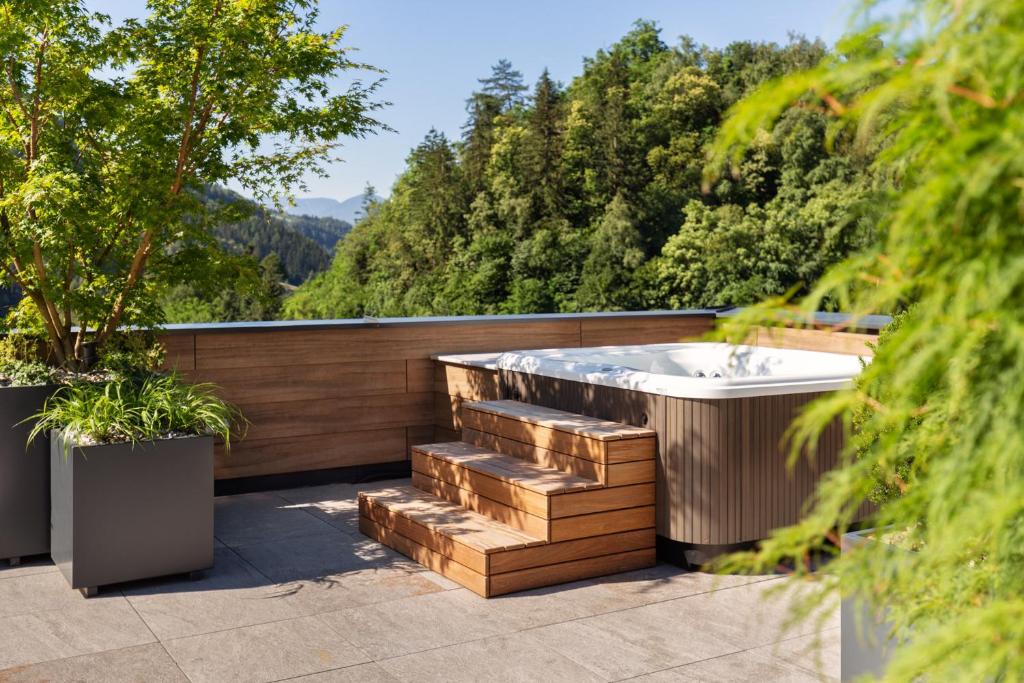 a jacuzzi tub on a patio with trees at Hotel Pension Sonnegg in Saltusio