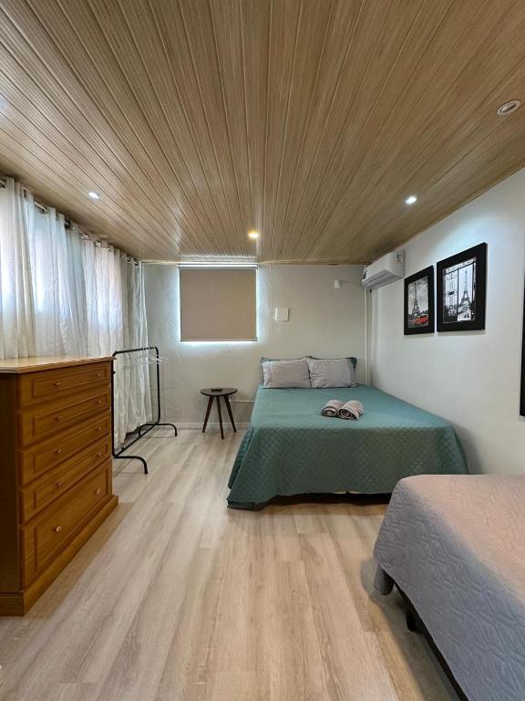 a bedroom with a green bed and a wooden ceiling at Studio Aconchegante - com Garagem Privativa e Ar Condicionado REV391 in Joinville