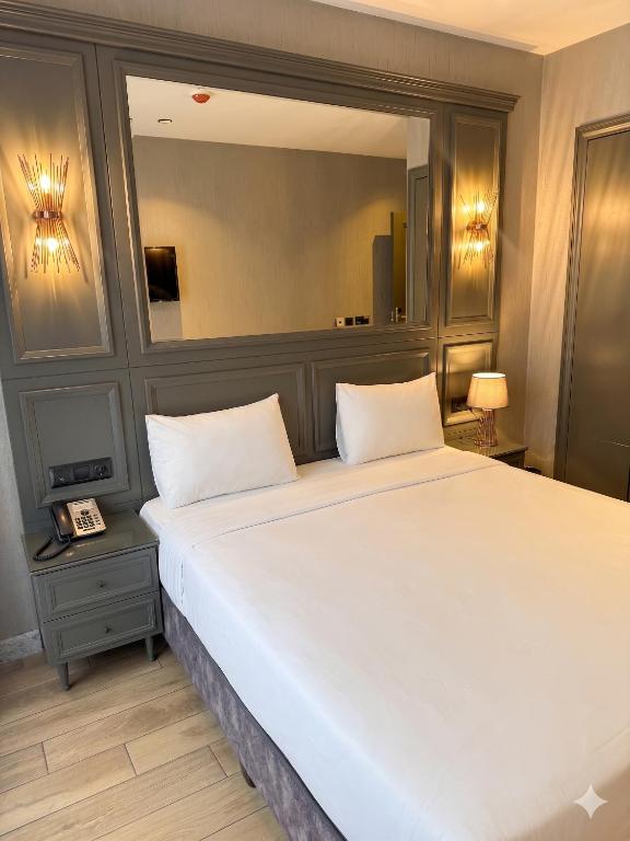 a bedroom with a large bed and a mirror at Peri Boutique Hotel Taksim in Istanbul