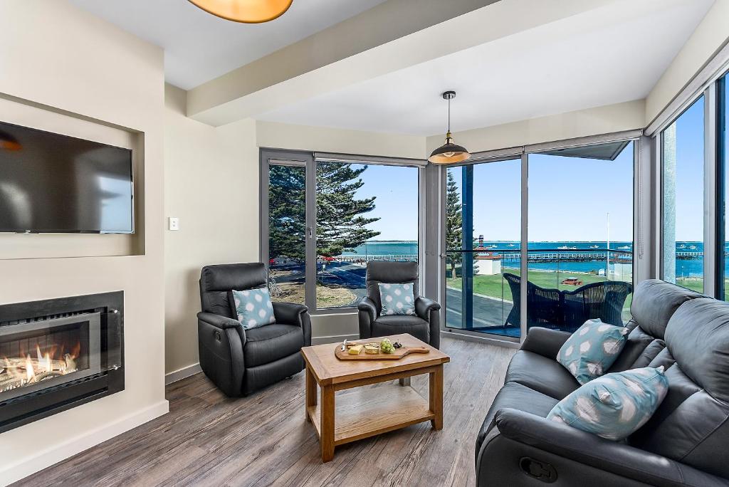 a living room with a couch and chairs and a fireplace at Bonnies of Beachport in Beachport