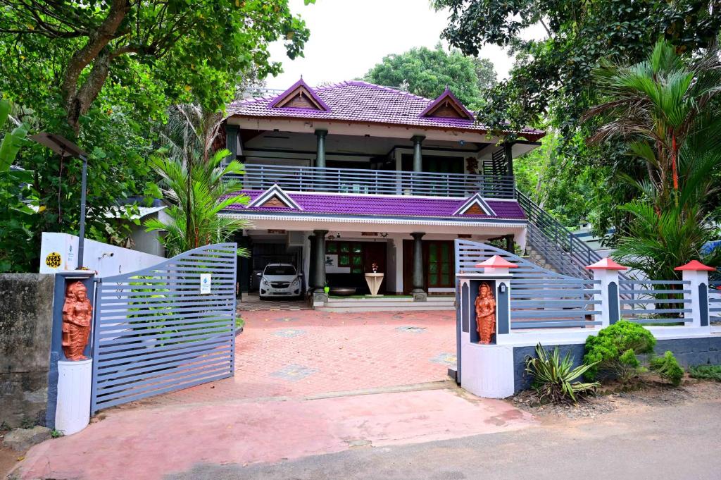 a house with a blue fence in front of it at Harbour villa 1 in Trivandrum