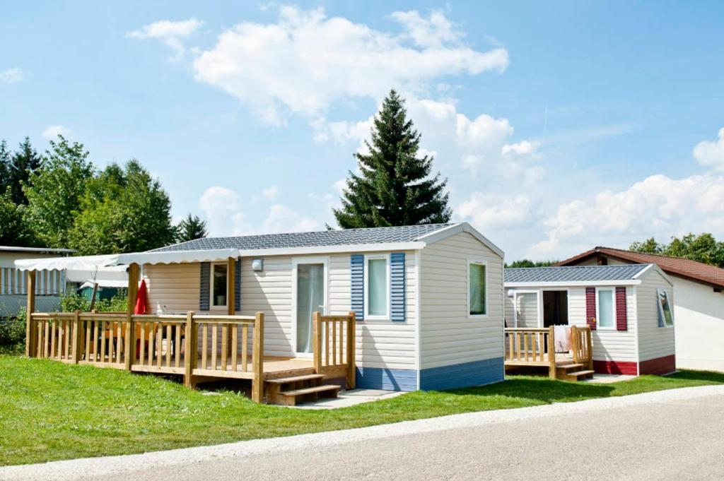 a tiny house with a porch and a deck at Mobilheim in Laichingen
