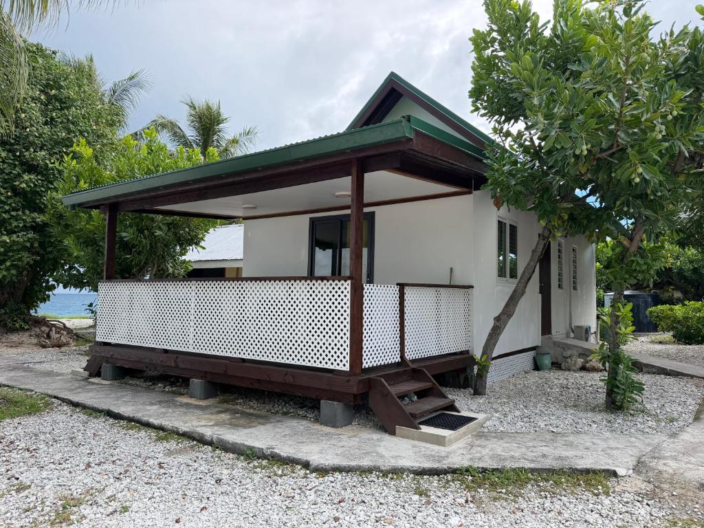 a small white house with a green roof at Ohotu Lodge in Rangiroa