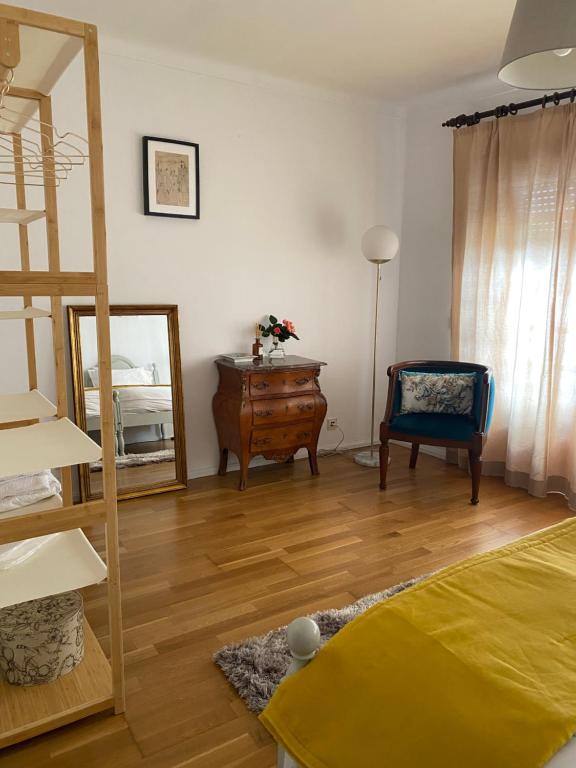 a room with a bed and a mirror and a chair at House in the Town Centre in Caminha