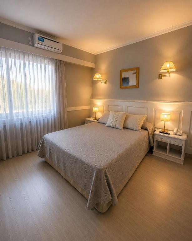 a bedroom with a large bed and two night stands at Hotel Valles in Mar del Plata