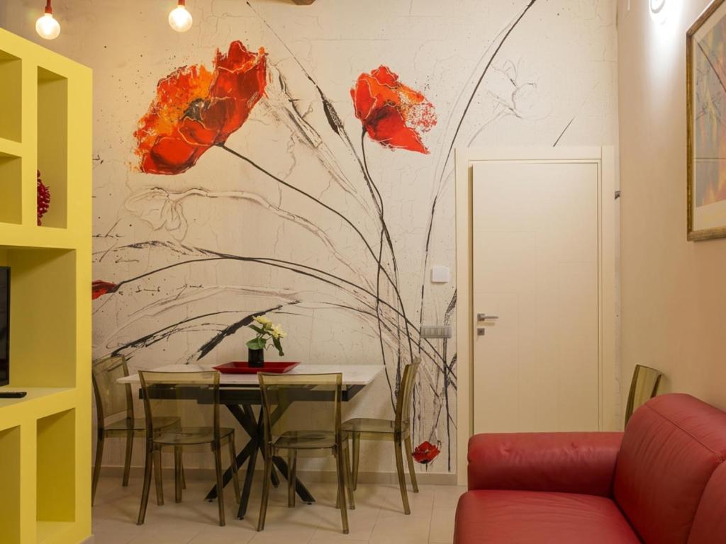 a dining room with a table and flowers mural on the wall at L'Abbraccio in Tivoli