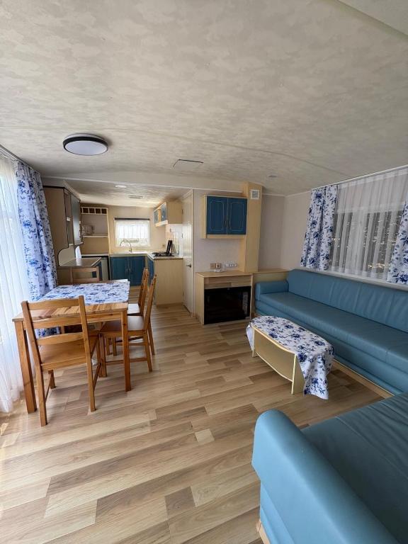a living room with a blue couch and a table at Domki Dolce Vita in Jastarnia