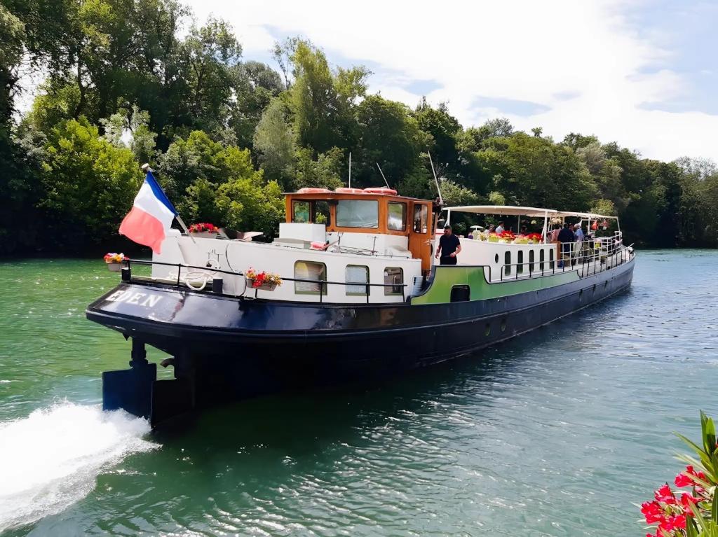 a boat with people on it in the water at Péniche - Eden in Samois-sur-Seine