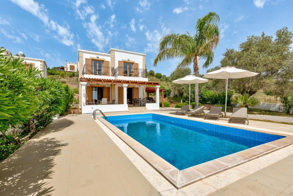 a villa with a swimming pool and a house at Villa AmberBlue Kalathos in Kalathos