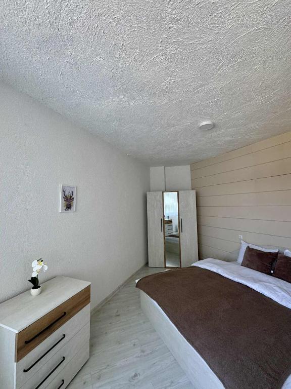 a bedroom with a bed and a white ceiling at Хижа Оборище in Oborishte