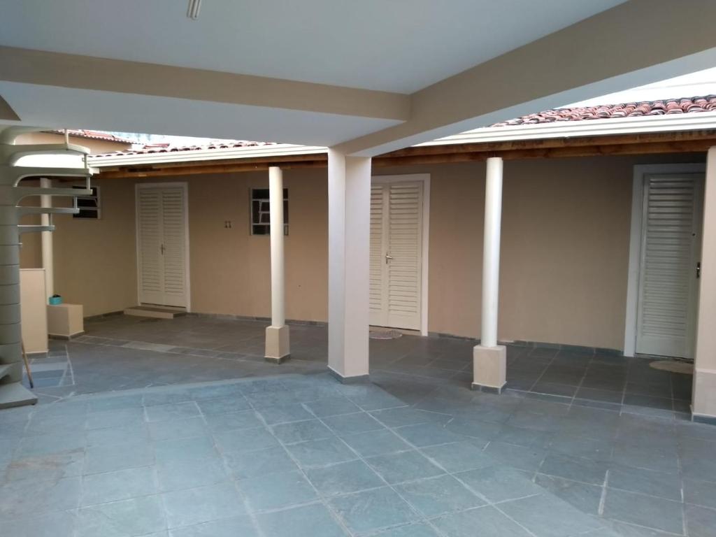 a room with white doors and a tile floor at Suites-II no centro de Salto SP in Salto