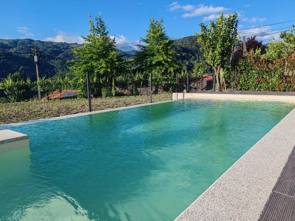 a swimming pool with turquoise water at Quinta da Lagoa - Gerês in Terras de Bouro
