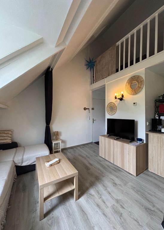 a living room with a couch and a table at Beau duplex coeur historique et plages in Dives-sur-Mer