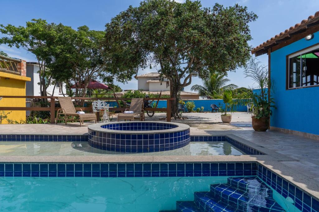 a swimming pool with a fire pit in a yard at Portal de Búzios in Armacao dos Buzios